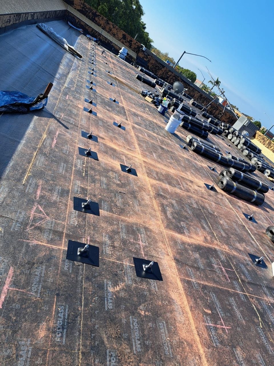 Polyglass modified-bitumen underlayment install with pre-set anchor pads for equipment and solar mounting — PBG roofing work.