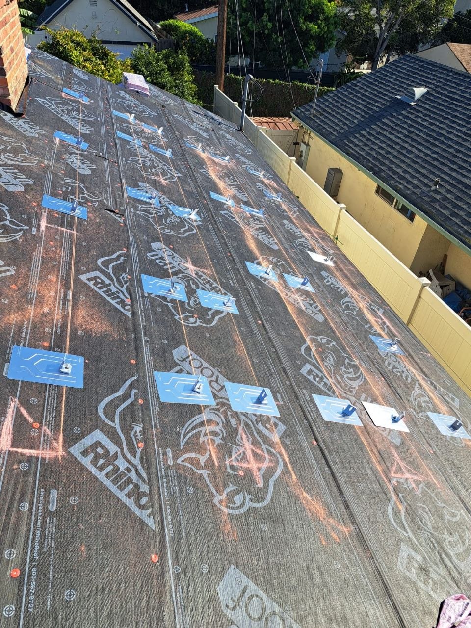 RhinoRoof U20 underlayment with clip pattern set to snapped chalk lines — clean layout craft detail from a PBG residential re-roof.