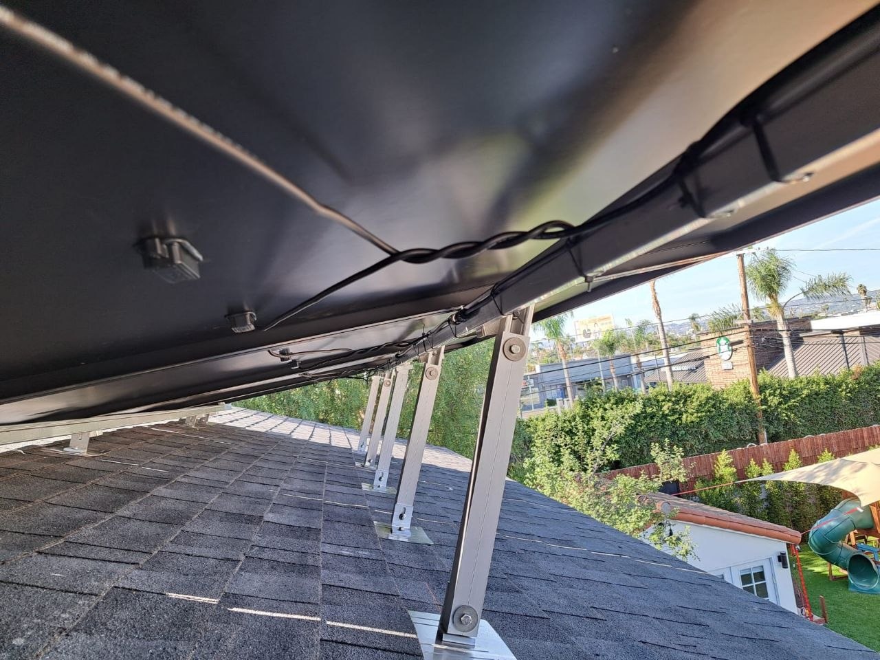 Underside of a tilt-mount array showing clean wiring and racking hardware — solar-integrated build by PBG, Los Angeles.