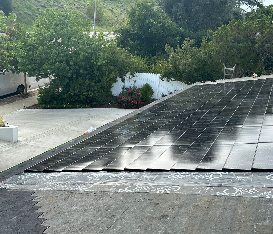 BIPV / flush-mount solar array installation over Grace Ice & Water Shield underlayment with hillside context — solar-integrated build by PBG, Los Angeles.