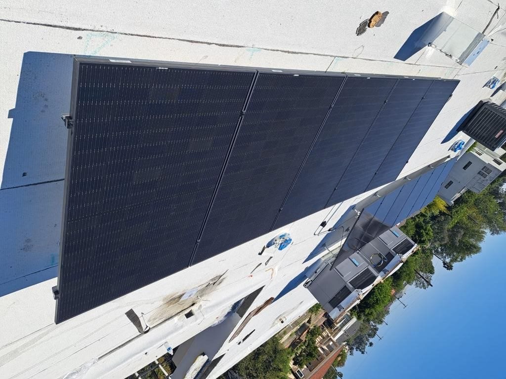 All-black solar array on a flat white membrane roof with HVAC integration — solar-integrated build by PBG, Los Angeles.