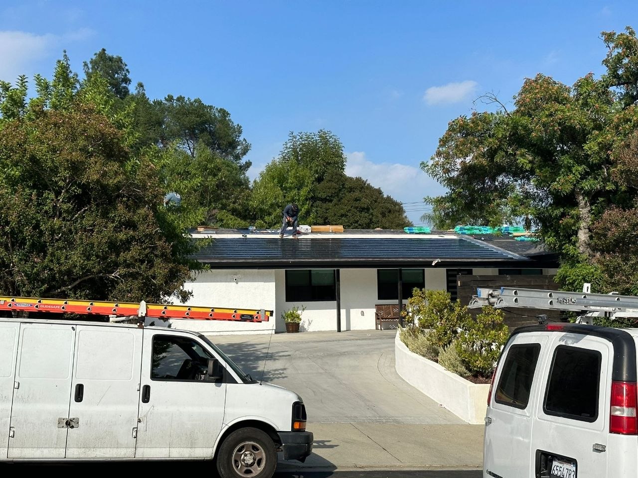 Solar shingle install in progress with PBG service vans on site — residential build, Los Angeles.