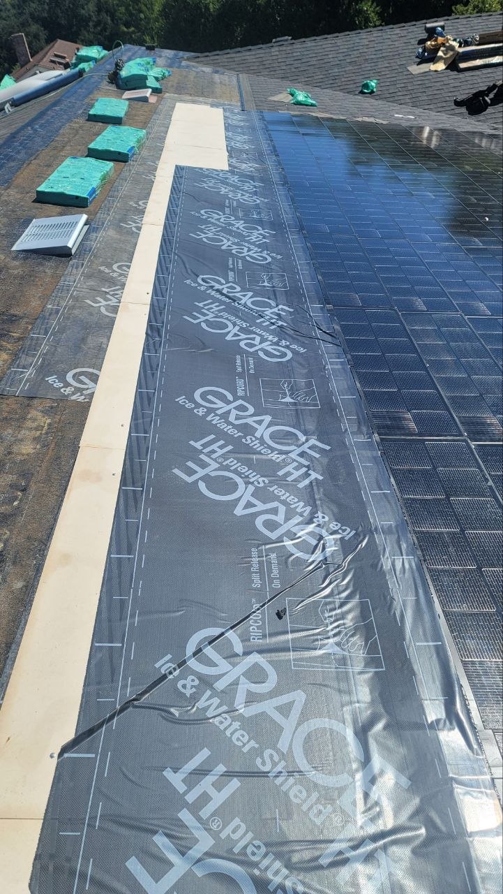Detail — solar shingles meeting Grace Ice & Water Shield underlayment next to composition shingles, showing the tie-in craftsmanship — PBG.